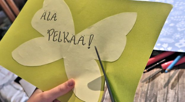 Kuvassa on perhosen muotoinen kortti, jossa lukee "Älä pelkää".