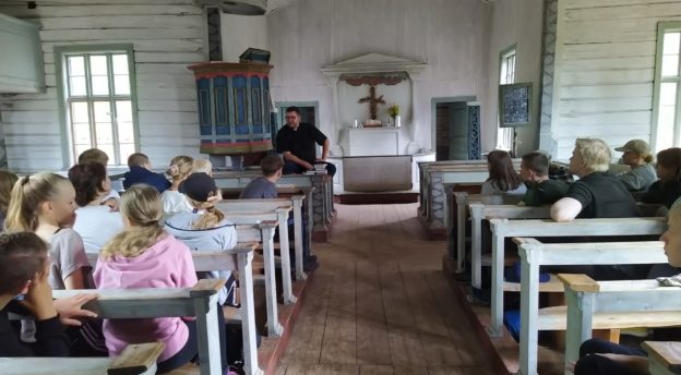 Toni Kokkonen opettaa riparilaisia kirkossa. 
