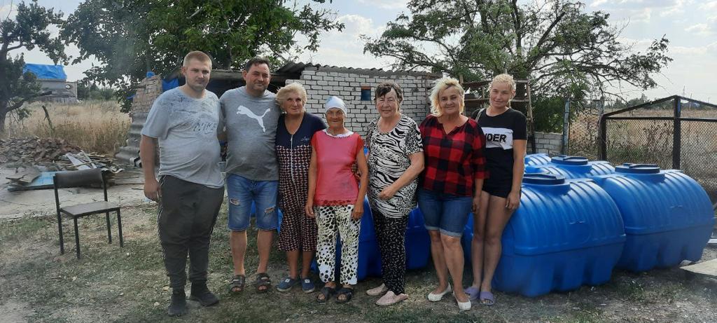 Ryhmä ukrainalaisia vastaanottamassa vesikontteja. Seurakuntalaiset kertoivat heille, mistä he voivat saada myös elävää vettä. 
